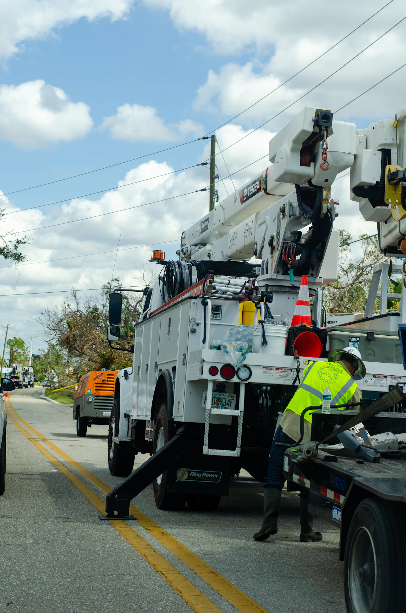 White utility truck with a worker in hi-vis