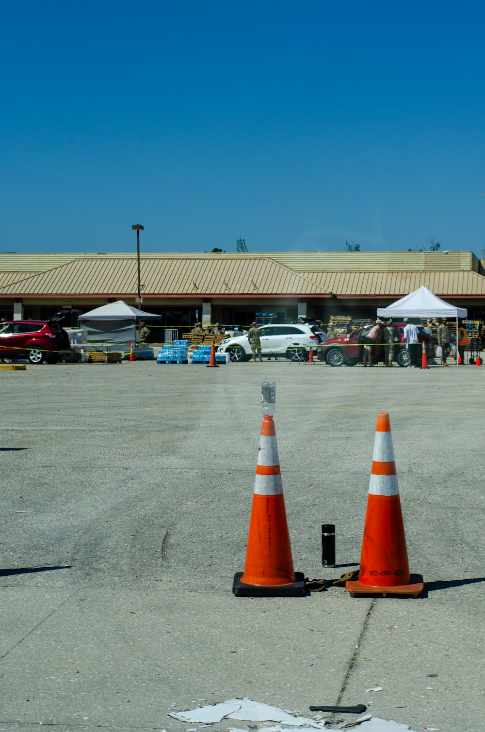 two orange and white cones sitting on top of an airport tarmac