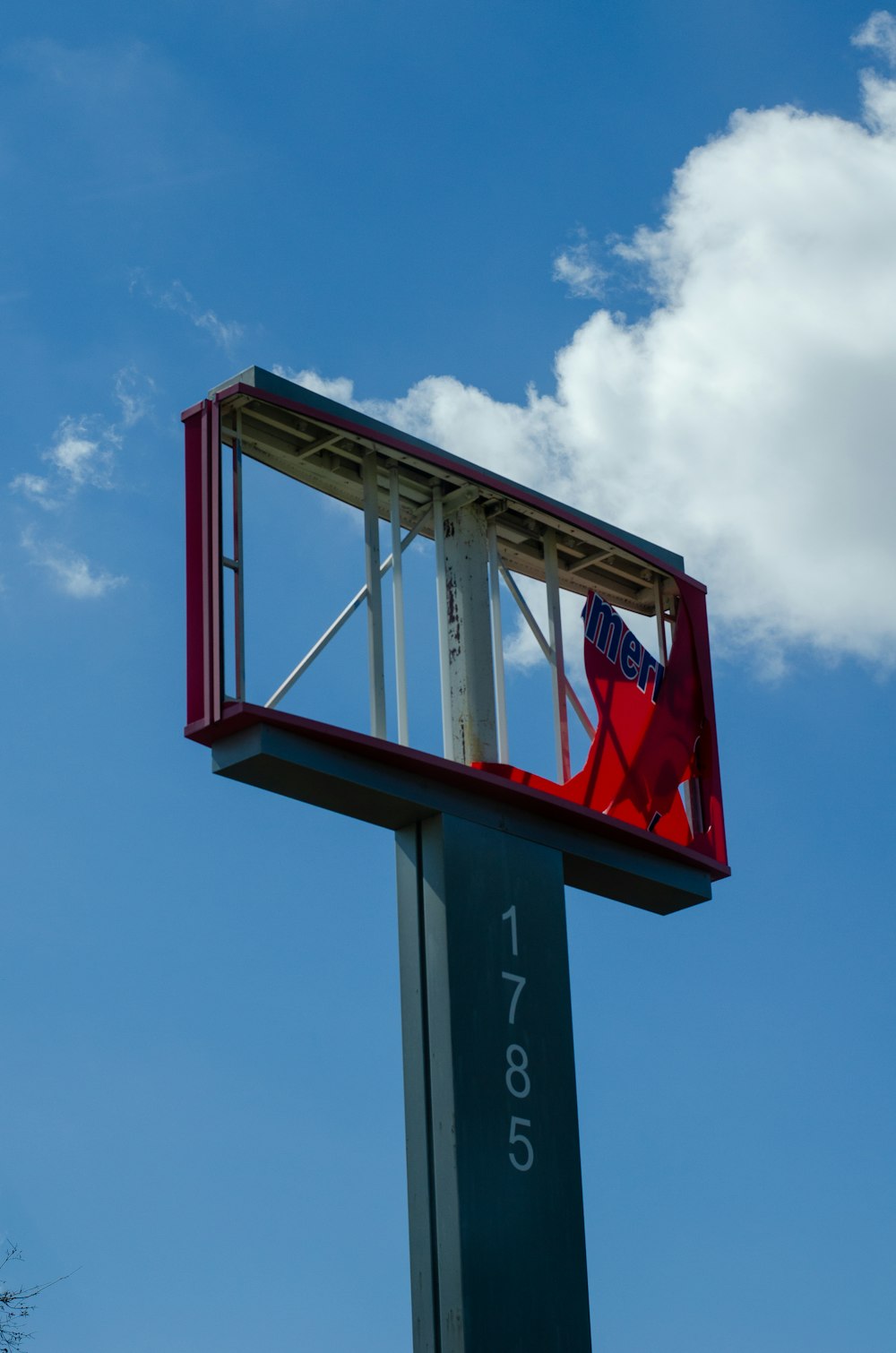 a red chair sitting on top of a tall sign