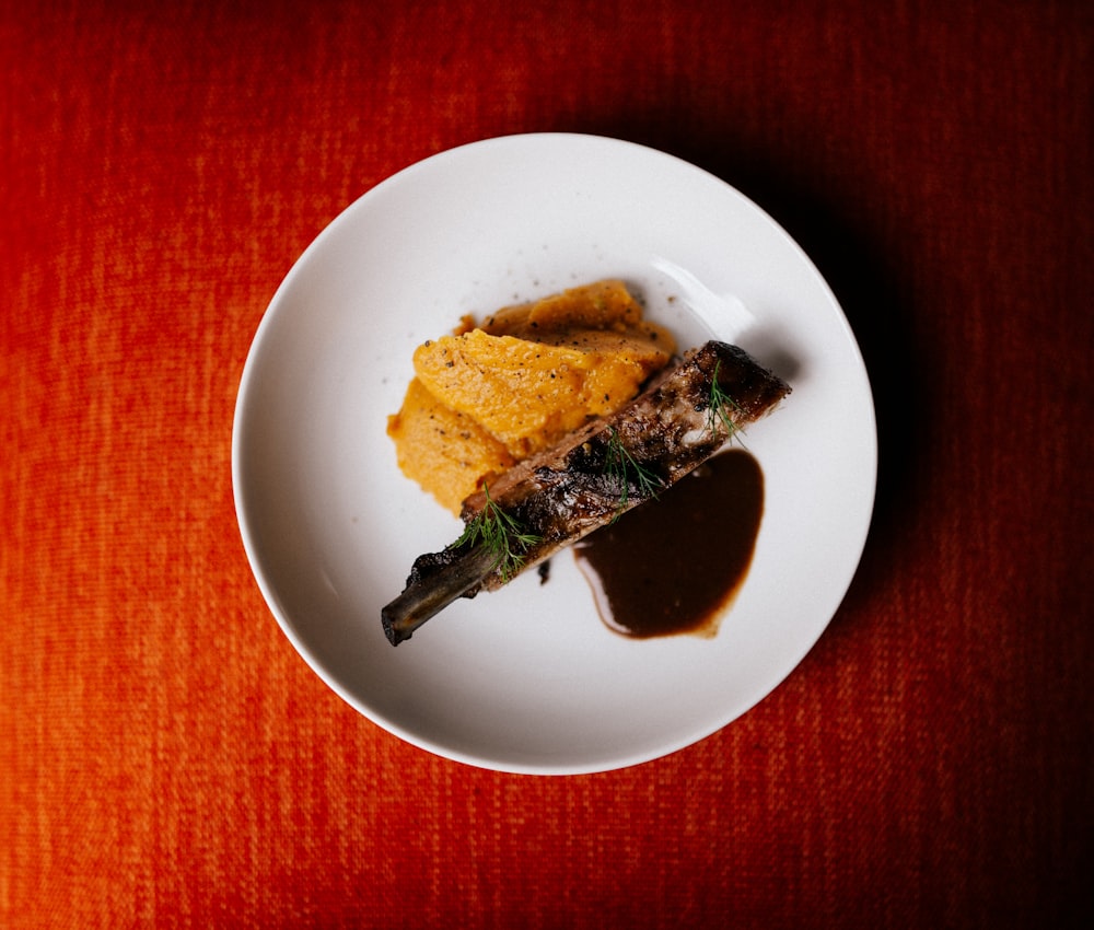 a white plate topped with food on top of a red table