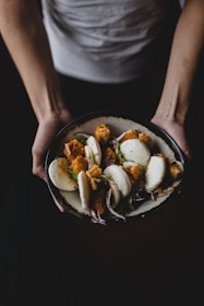 Close-up of a steaming chicken bun with savory filling bursting from the soft bun.