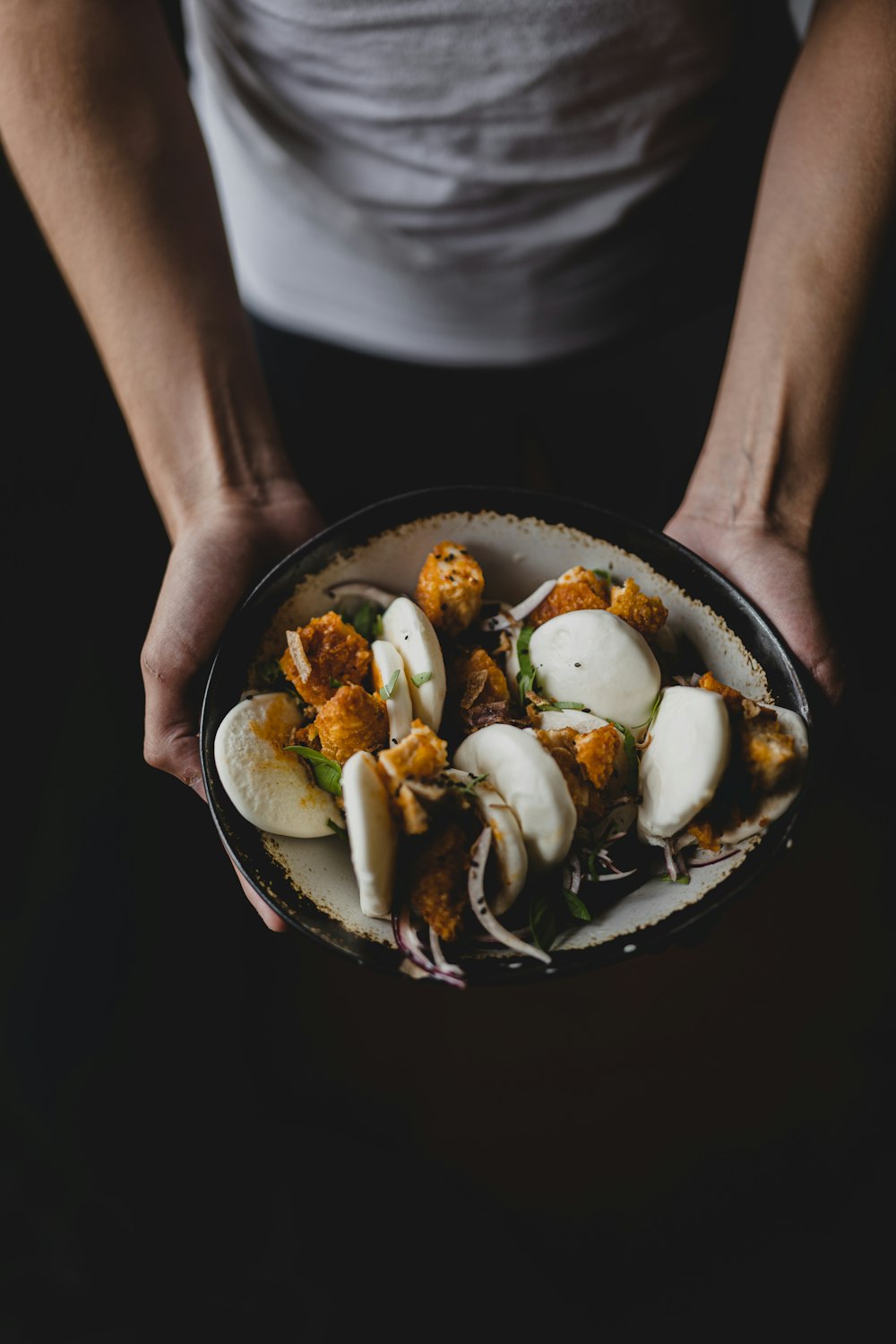 a person holding a bowl of food in their hands