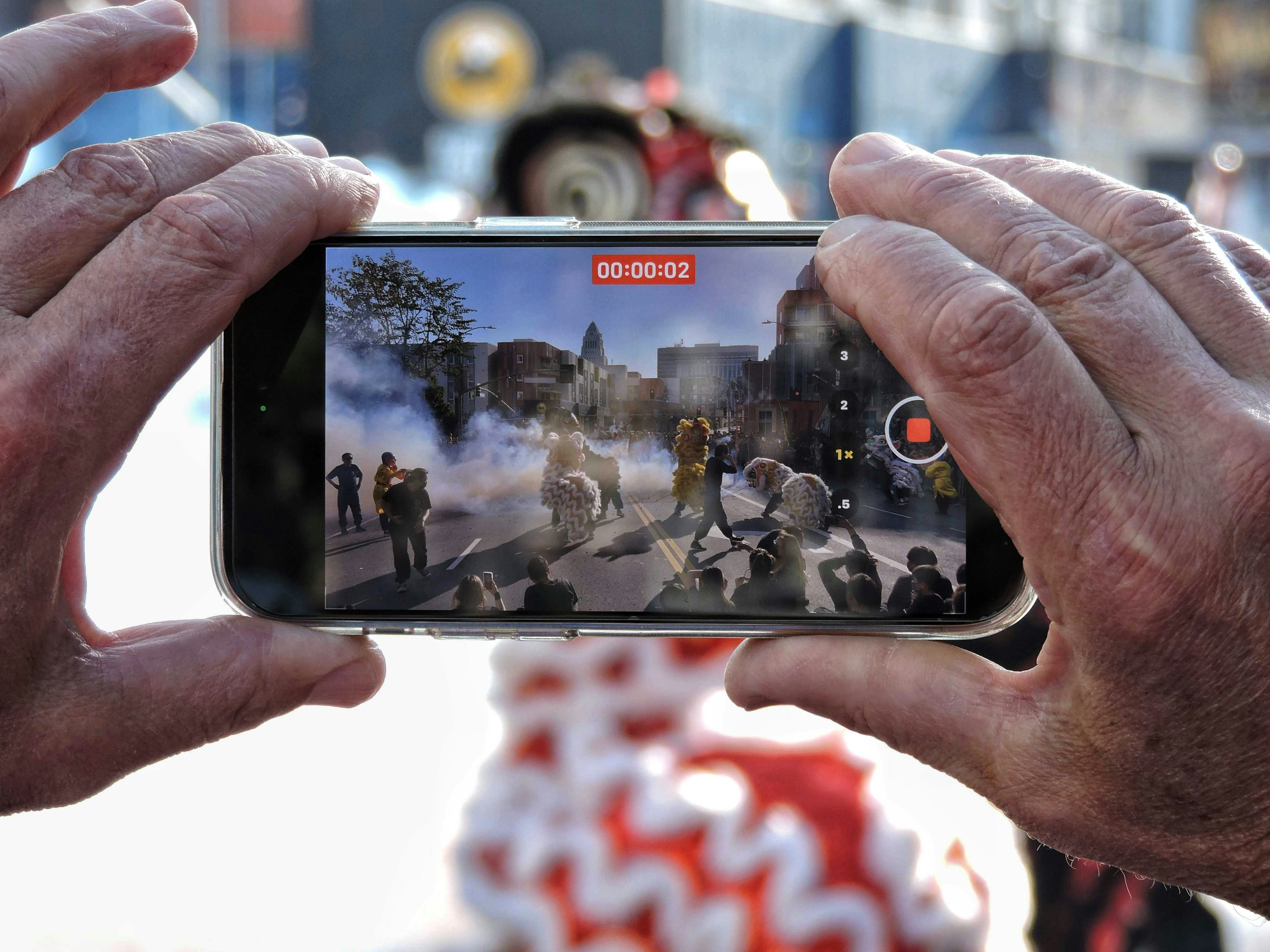 a person taking a picture of a group of people on a street