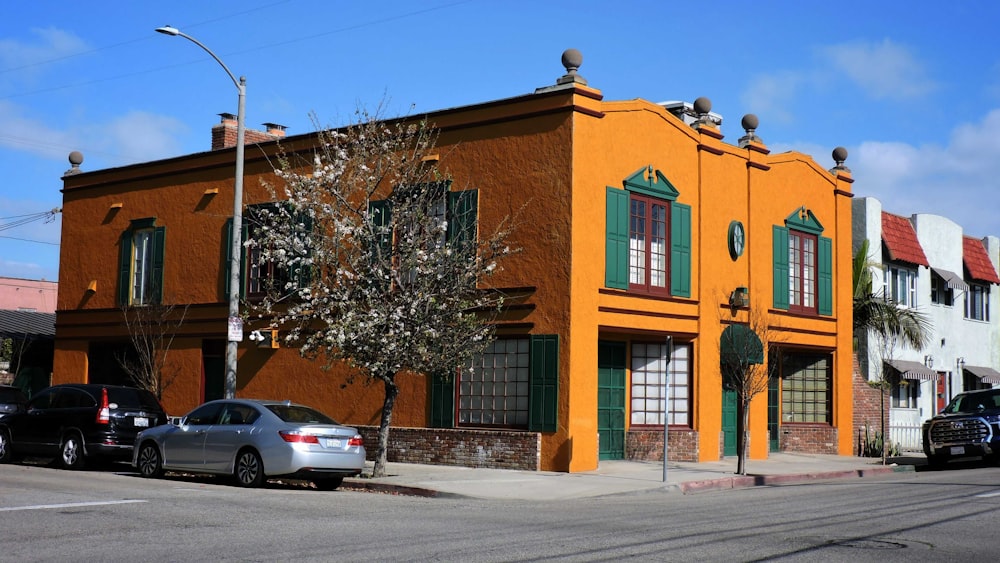 an orange building with green shutters on a street corner