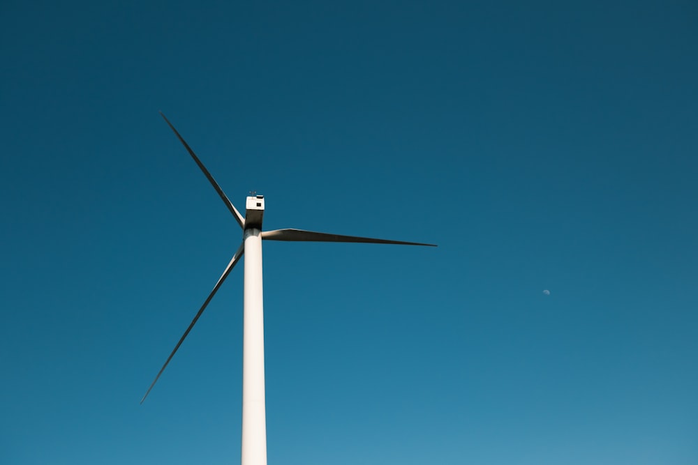 a wind turbine in the middle of a clear blue sky