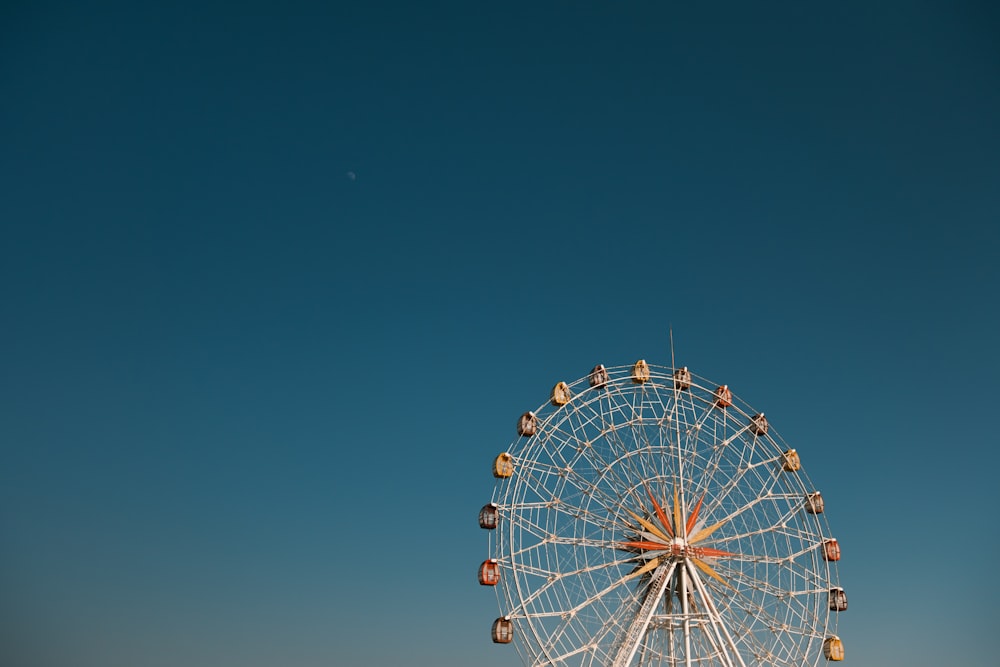 uma roda gigante com um céu azul no fundo