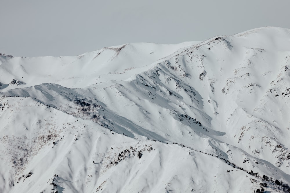 a mountain covered in snow with a sky background