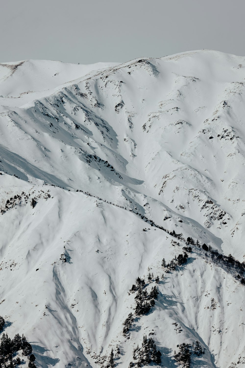 a mountain covered in snow with a sky background