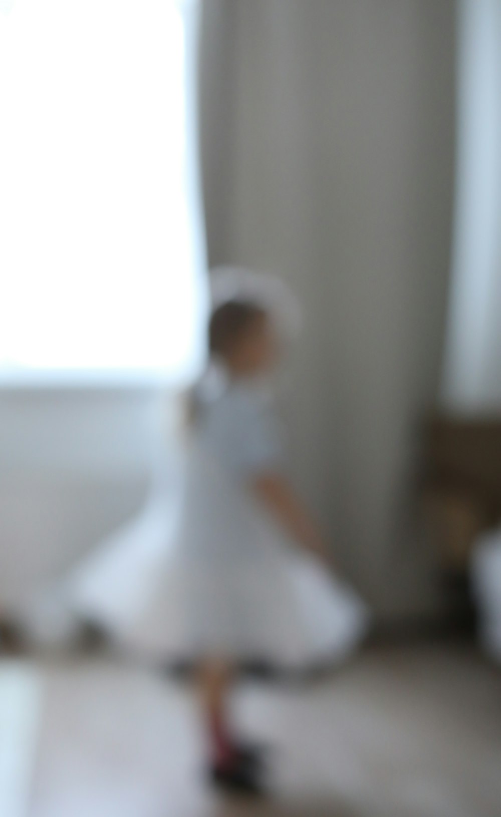 Una foto sfocata di una bambina in un vestito bianco