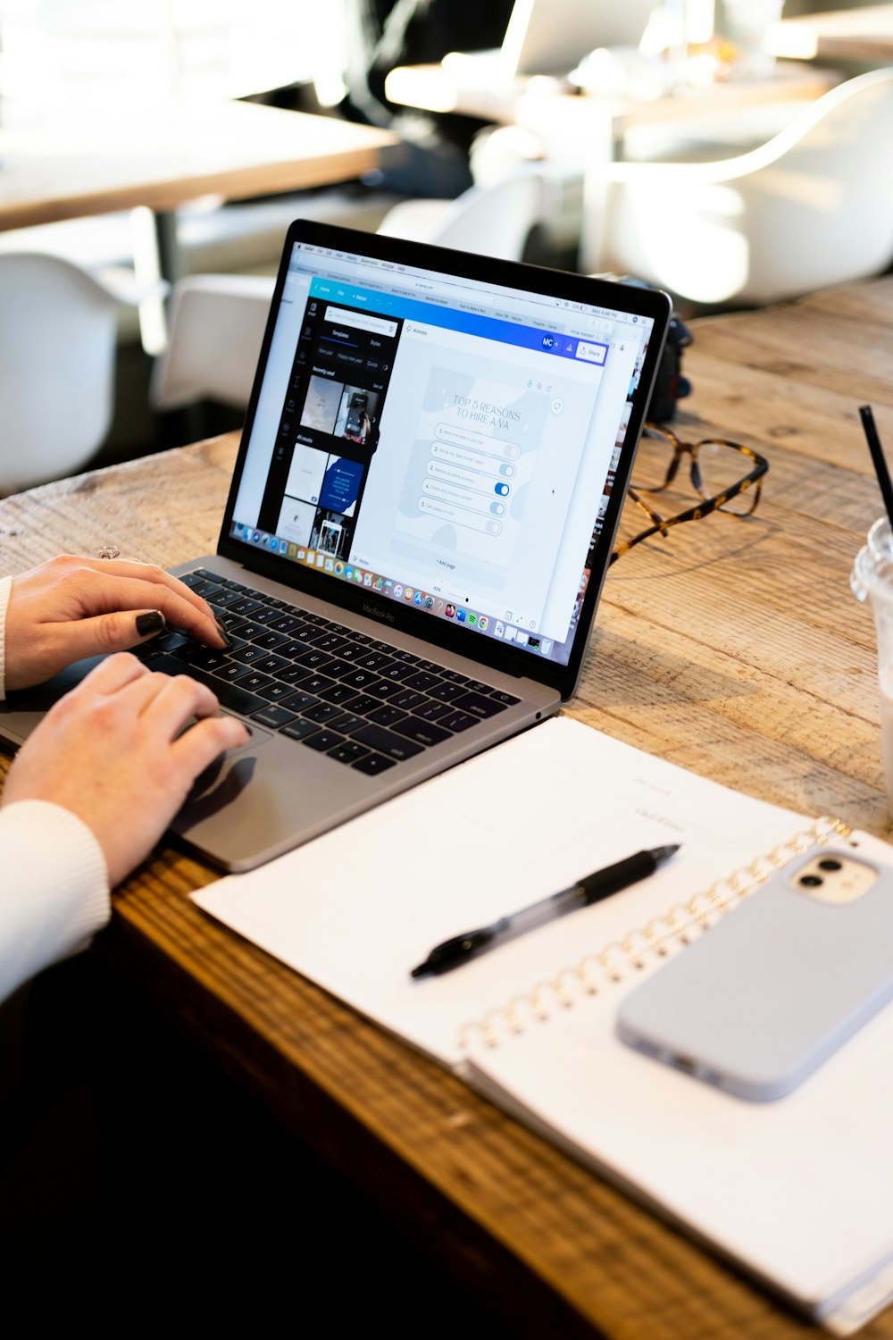 a person using a laptop on a wooden table