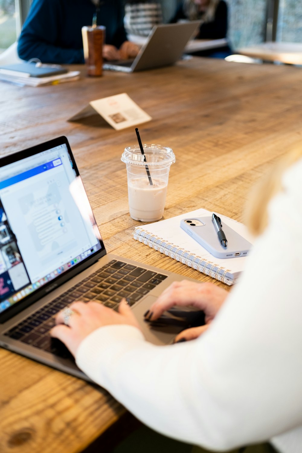 a woman sitting at a table using a laptop computer