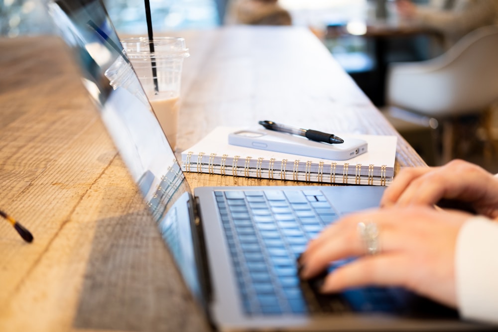 a person typing on a laptop on a table