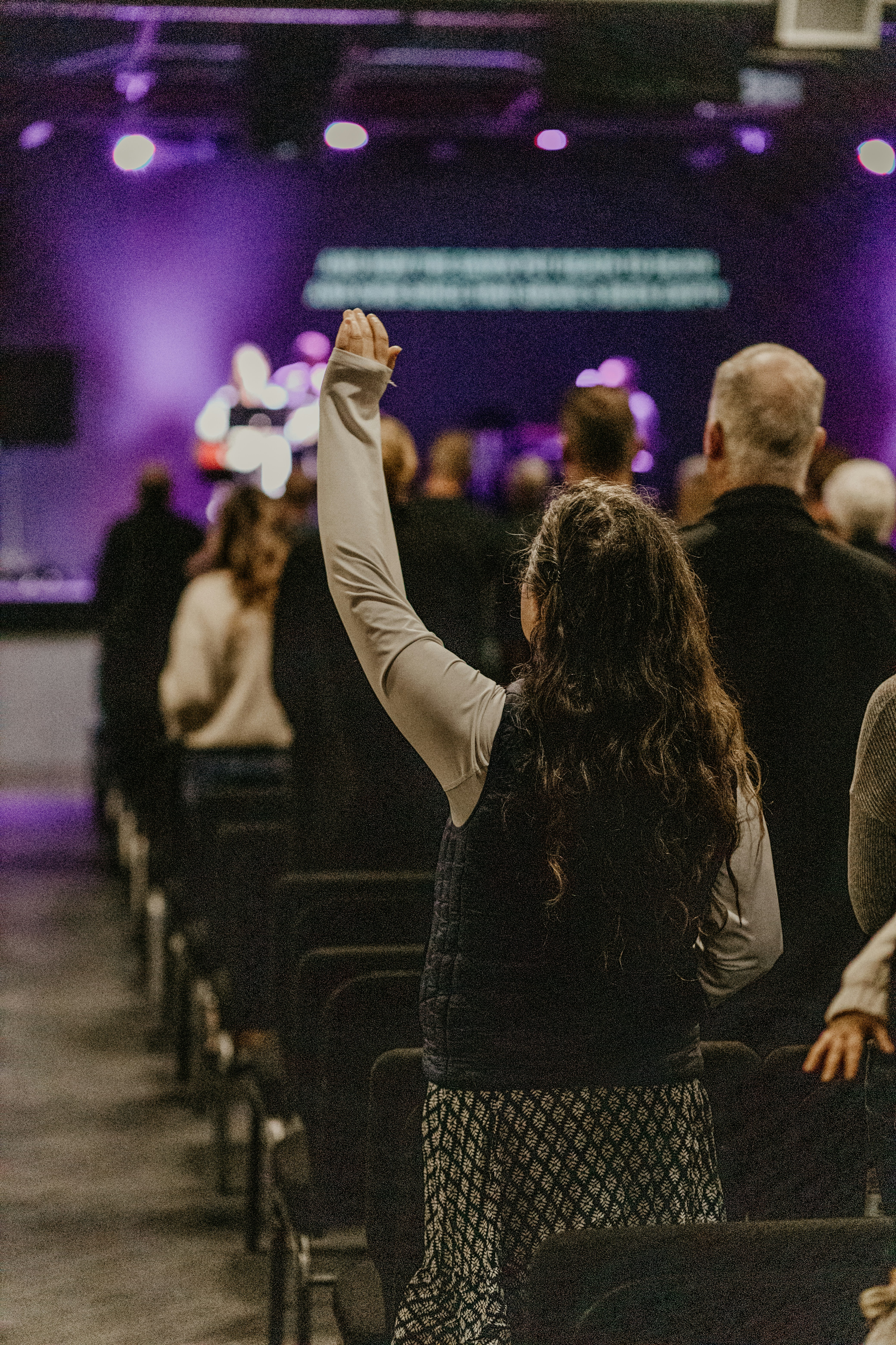 a woman raising her hand in a church