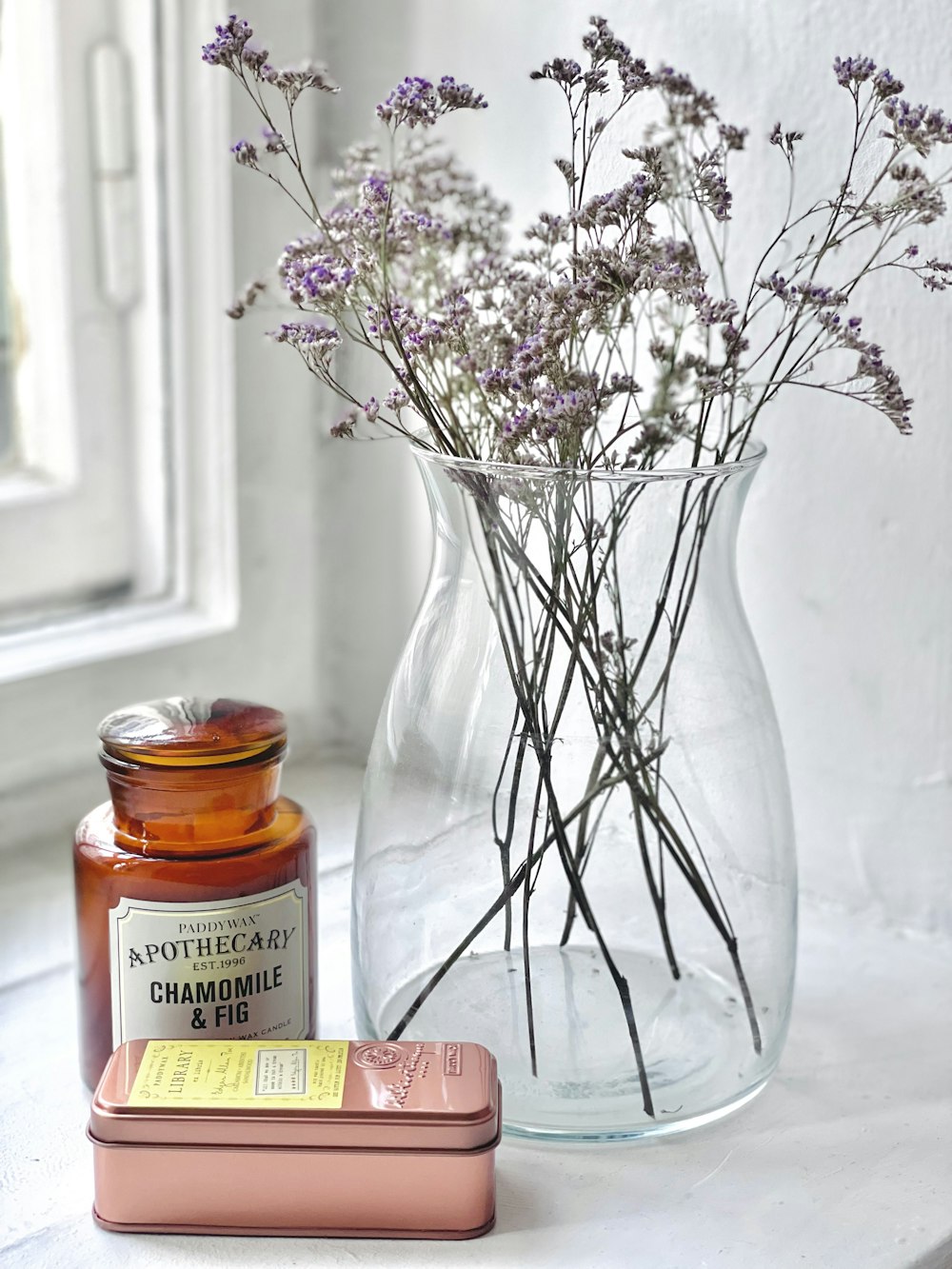 a jar of honey next to a jar of flowers