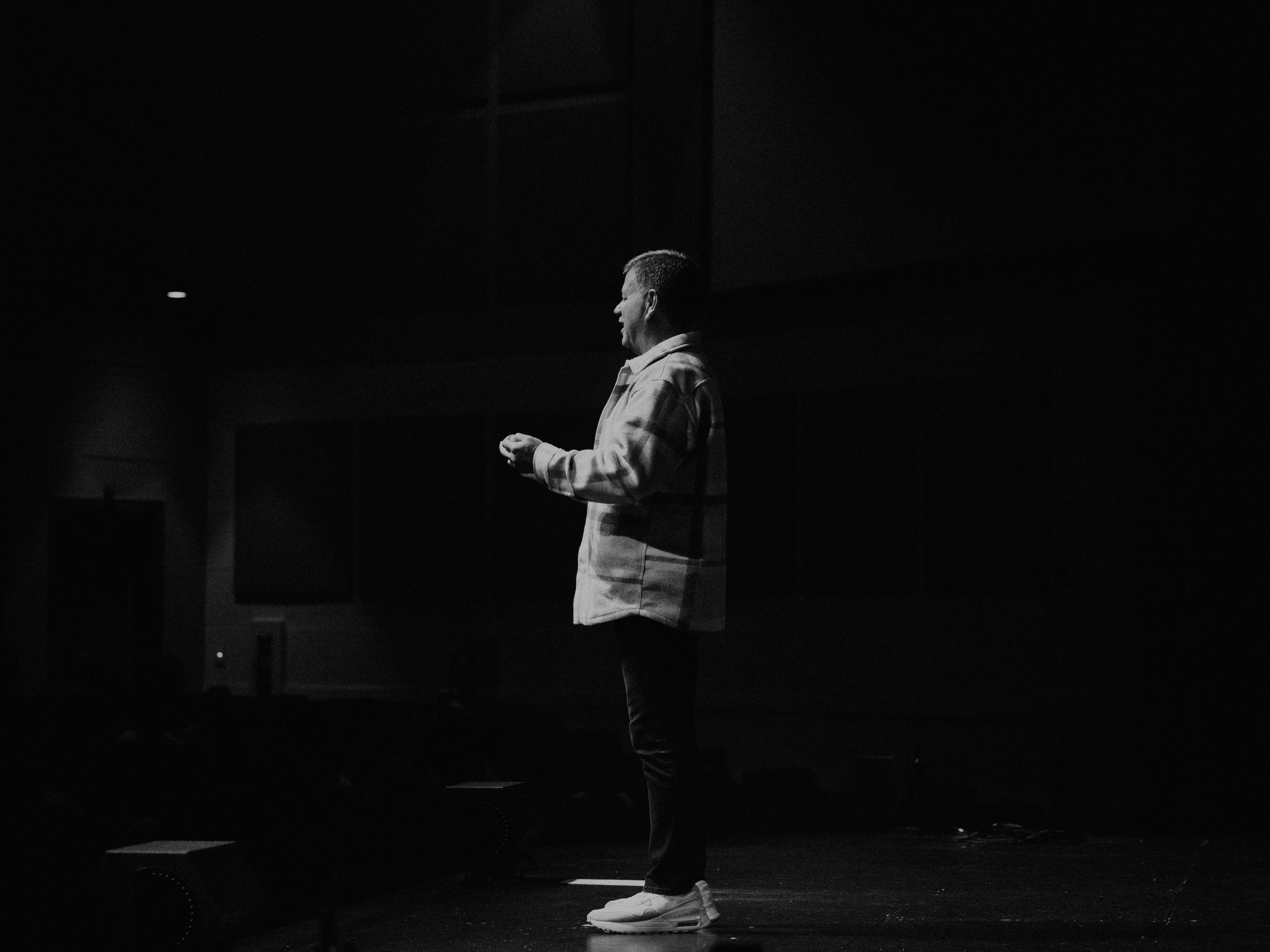 a man standing on a stage in a dark room