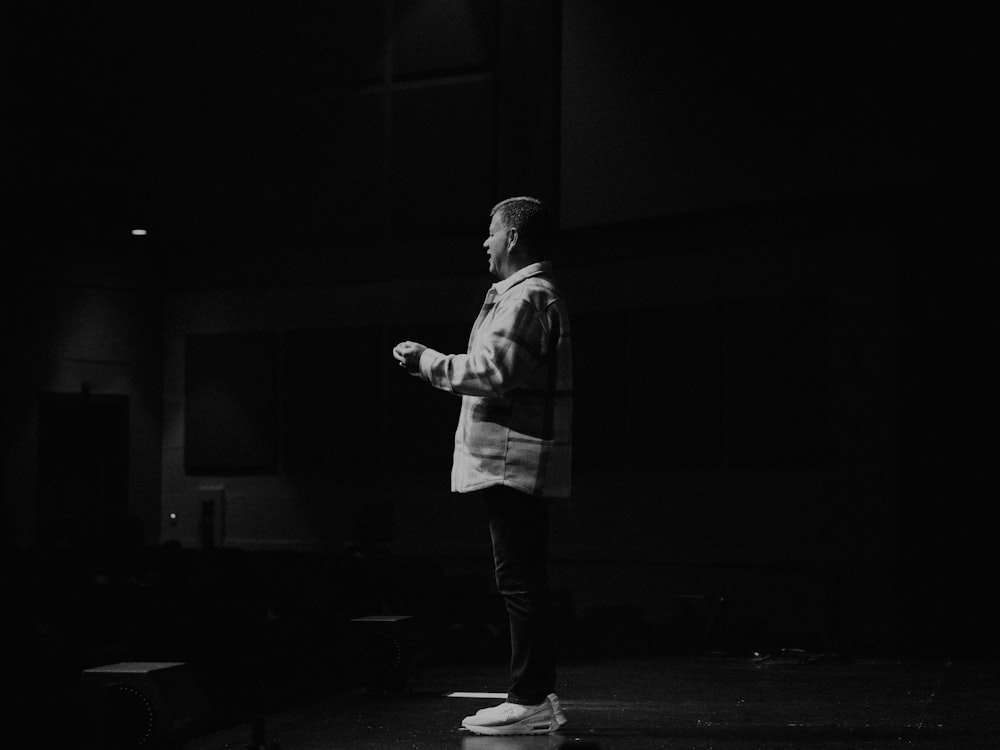 a man standing on a stage in a dark room