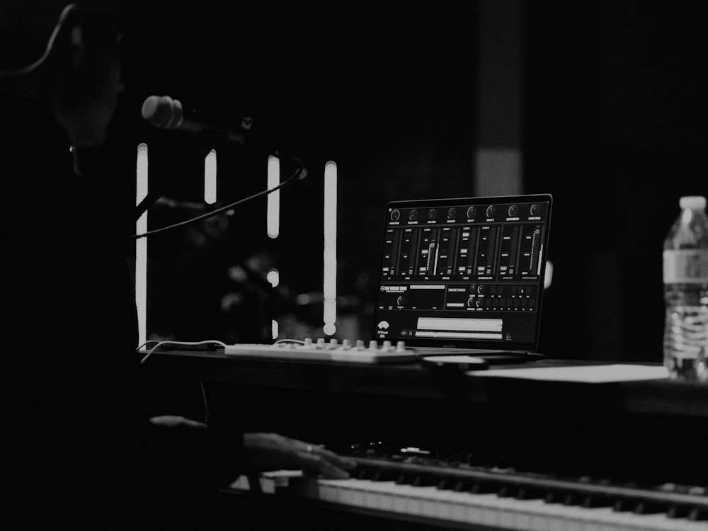 a black and white photo of a keyboard and a bottle of water