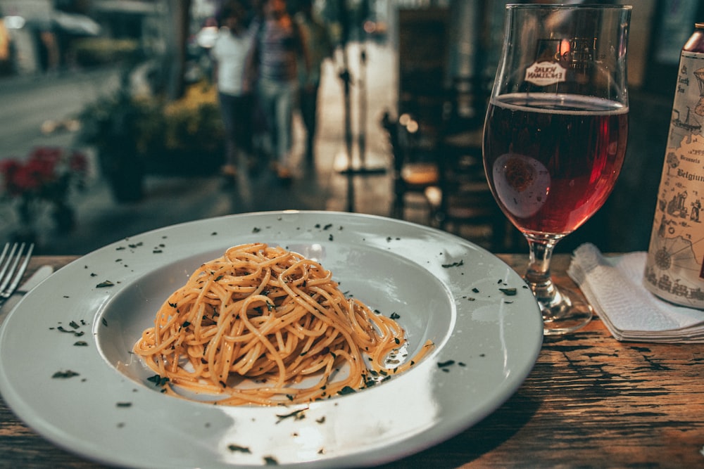 a plate of spaghetti and a glass of wine