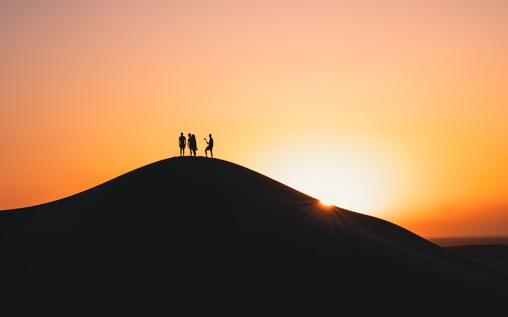 a group of people standing on top of a hill