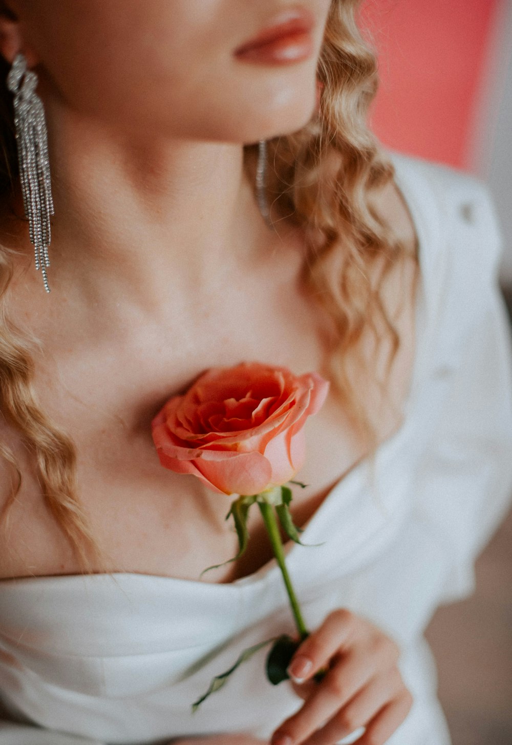 a woman in a white dress holding a rose