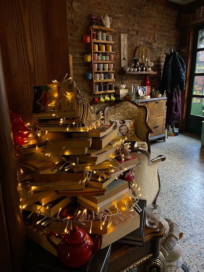 A cozy reading nook with a stack of colorful fiction novels and a steaming cup of tea.