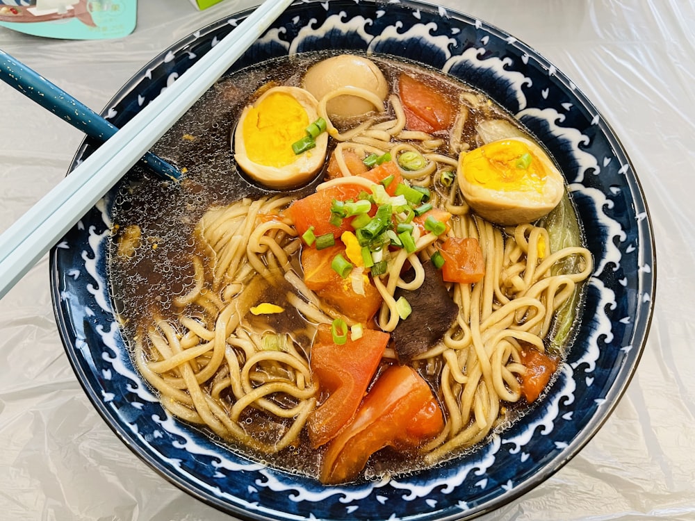 a bowl of ramen with chopsticks on the side