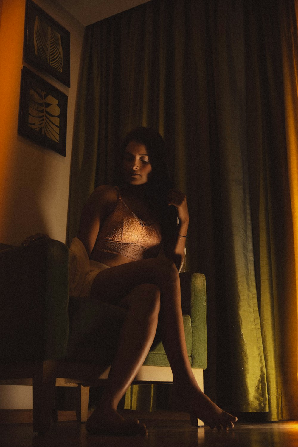 a woman sitting on a chair in a dimly lit room