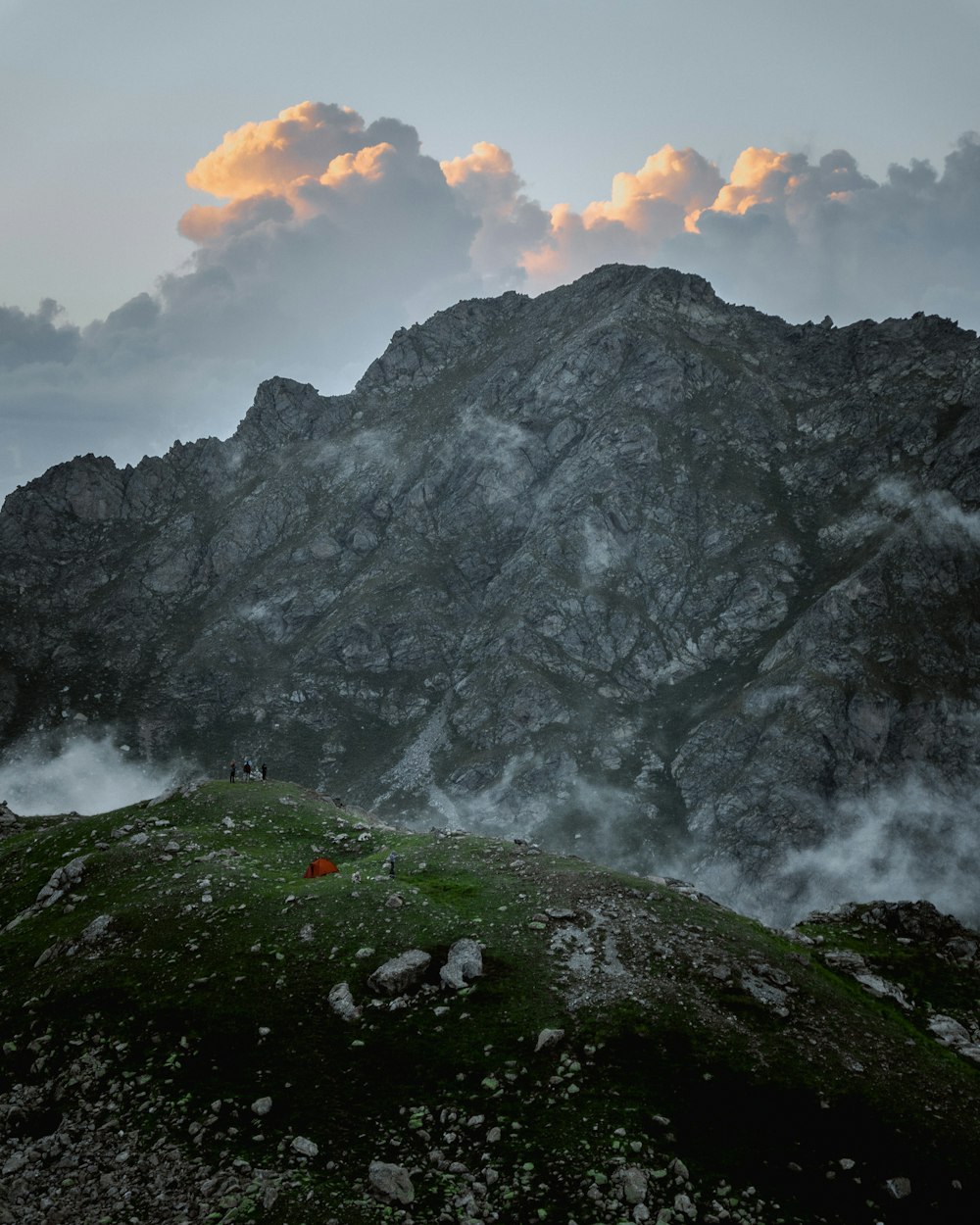 a person standing on top of a mountain under a cloudy sky