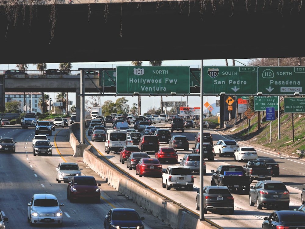 a highway filled with lots of traffic under a bridge