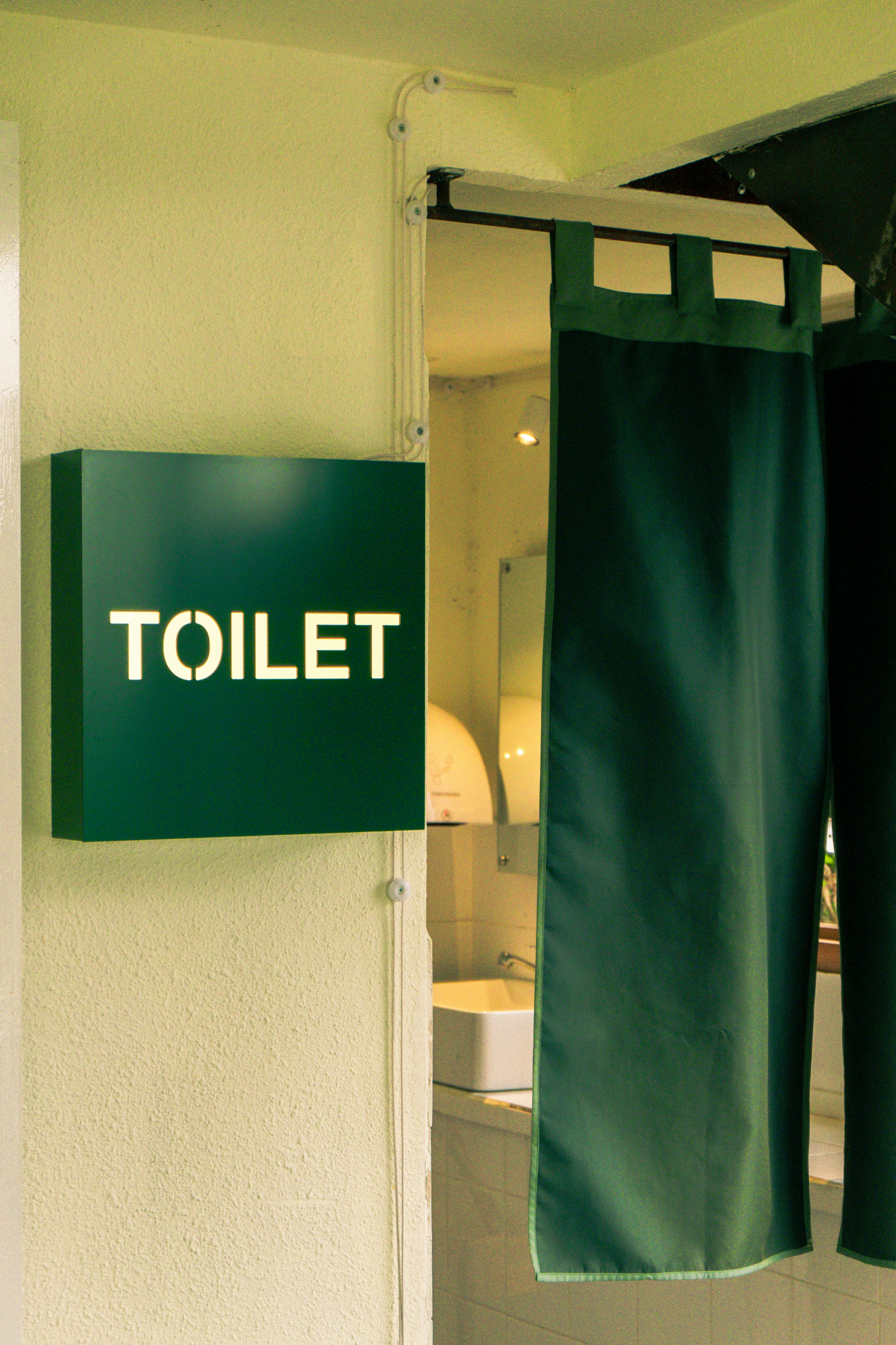 un baño con una toalla verde colgada en la pared