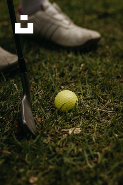 A golf ball sitting on the ground next to a golf club photo – Free Golf ...