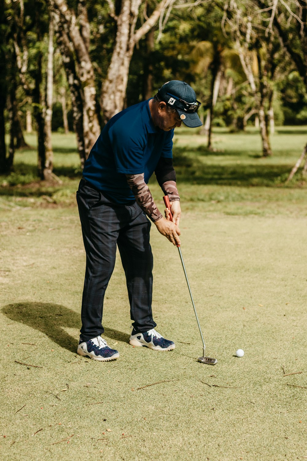 Un homme en chemise bleue et pantalon noir jouant au golf photo – Photo La  personne Gratuite sur Unsplash