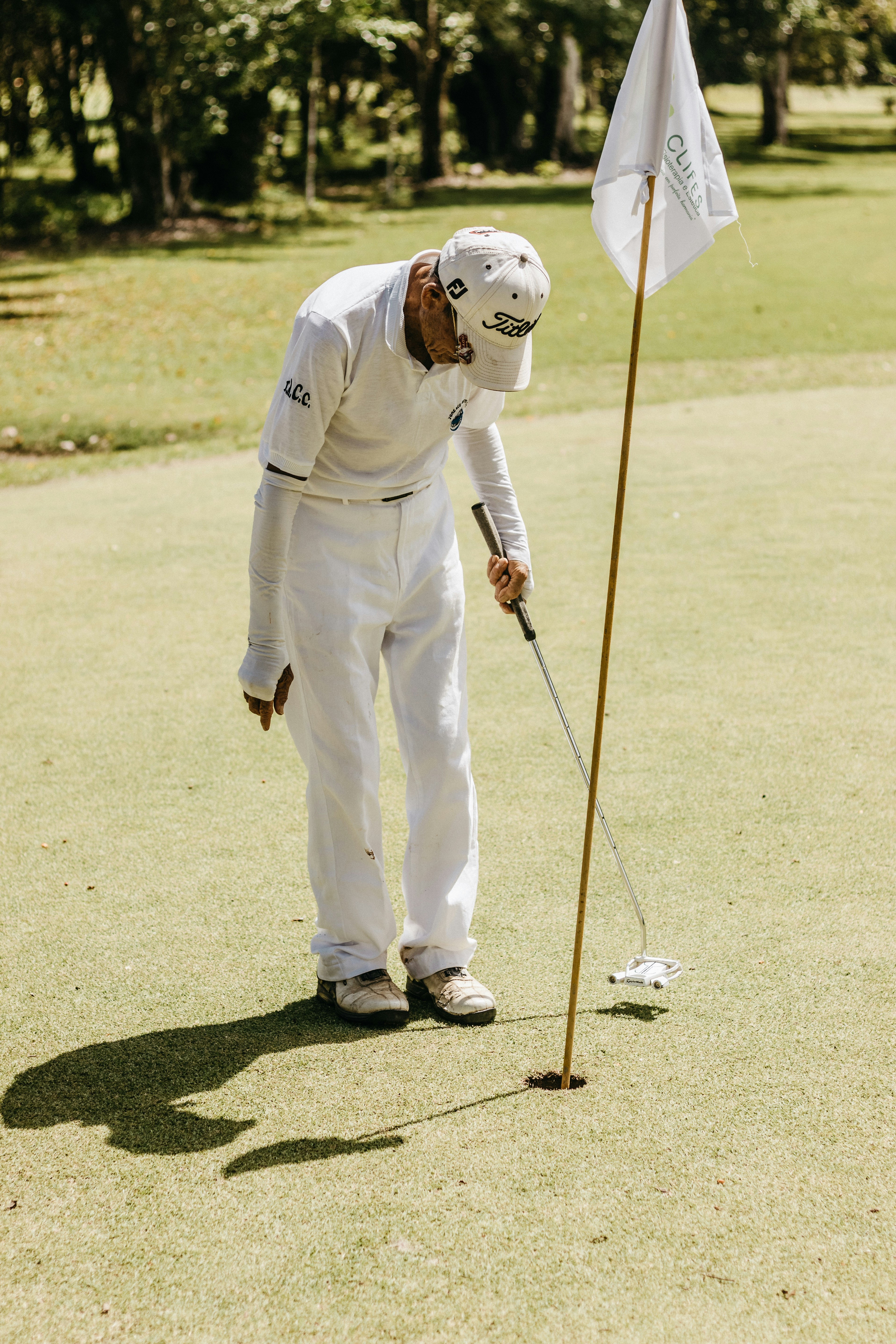 a man putting a flag on a golf course