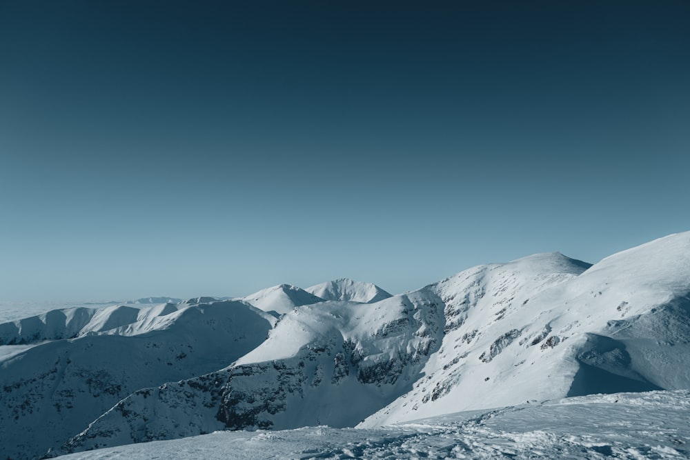 a person standing on top of a snow covered mountain