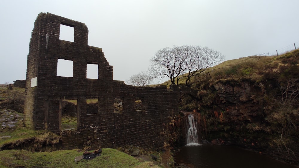 an old brick building with a waterfall in the middle of it