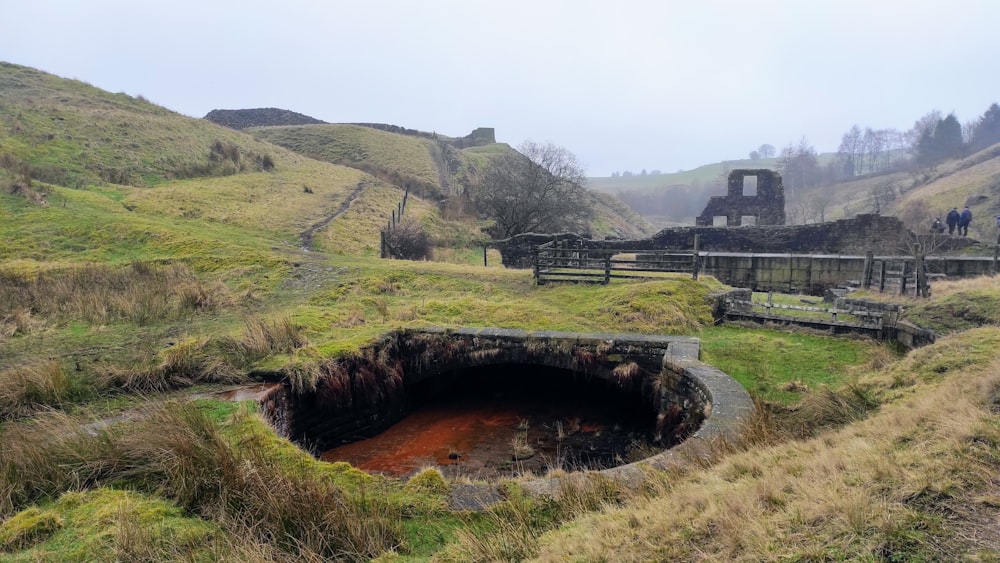 a hole in the ground in a grassy field