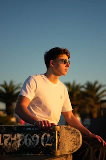 A vibrant streetwear outfit worn by a young man skateboarding in an urban park at sunset.