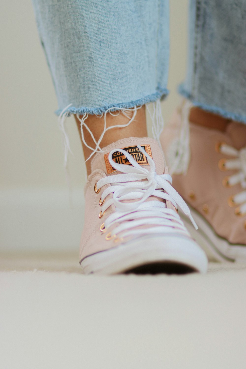 a close up of a person's feet wearing pink sneakers
