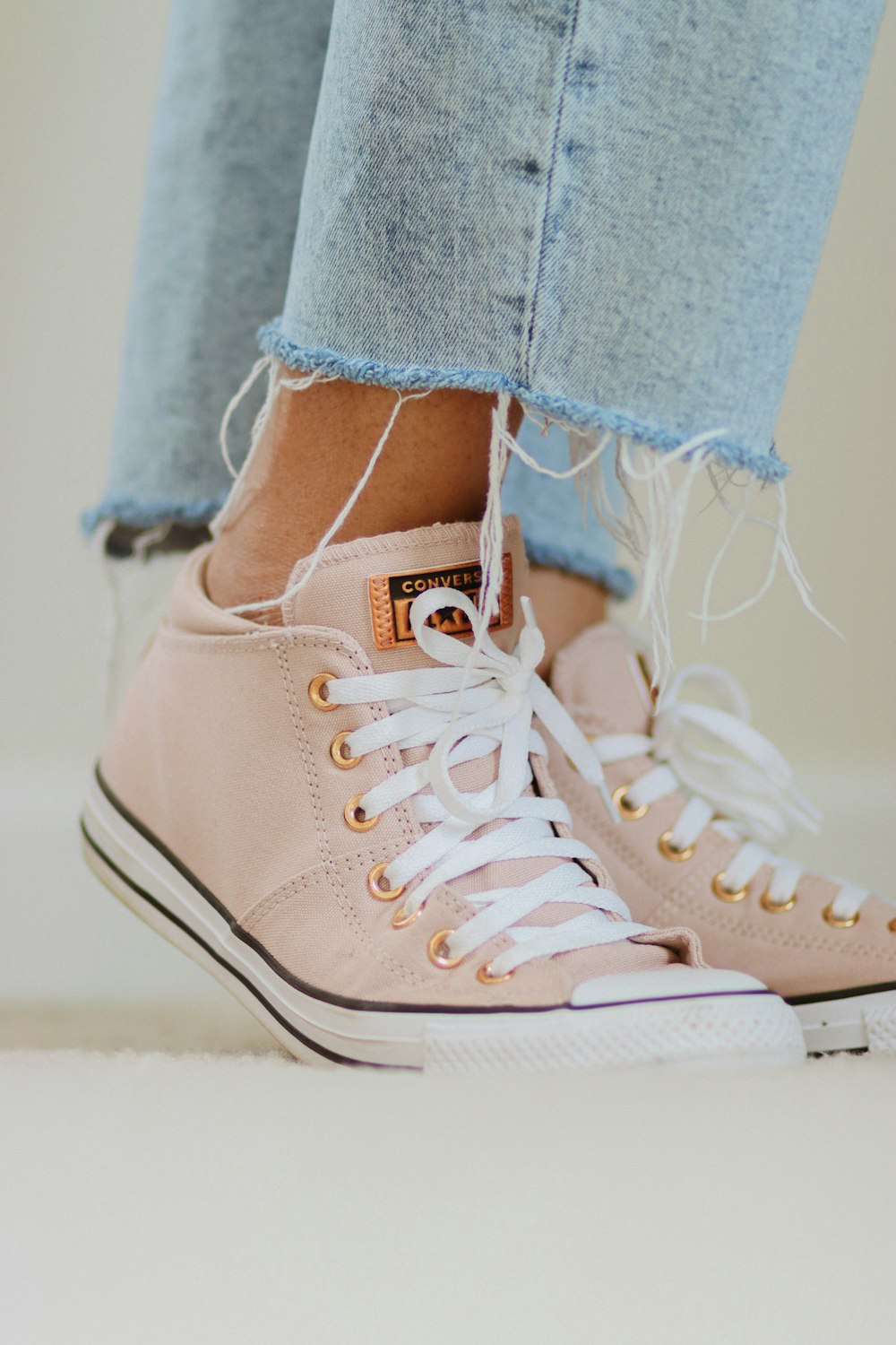 a close up of a person wearing pink sneakers