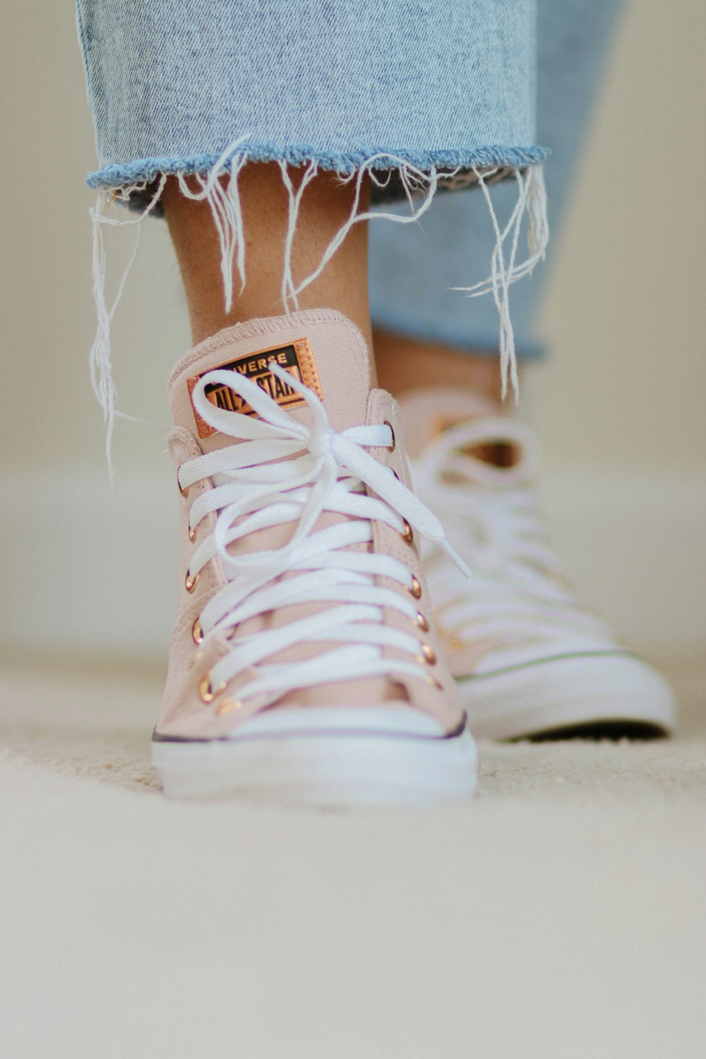 Un primer plano de los pies de una persona con zapatillas rosas y blancas