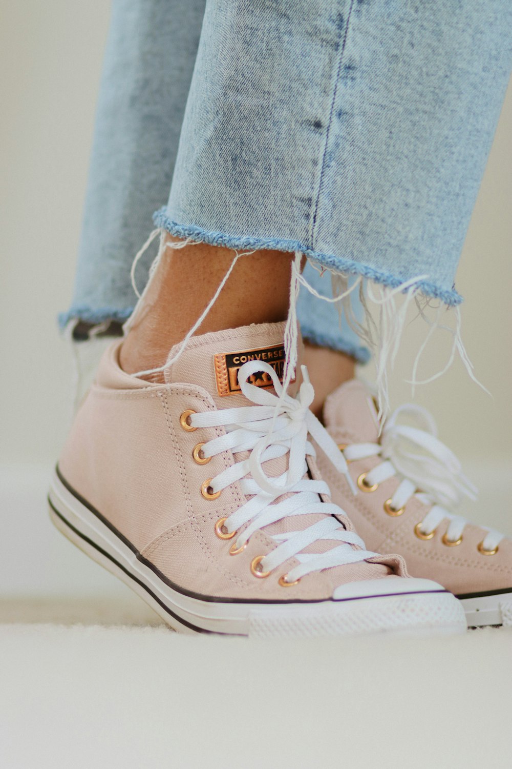 a close up of a person's feet wearing pink sneakers