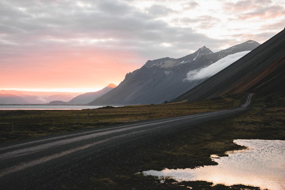 a dirt road with a mountain in the background