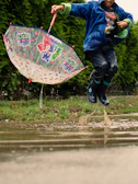 Animated children laughing and jumping in puddles on a rainy day.