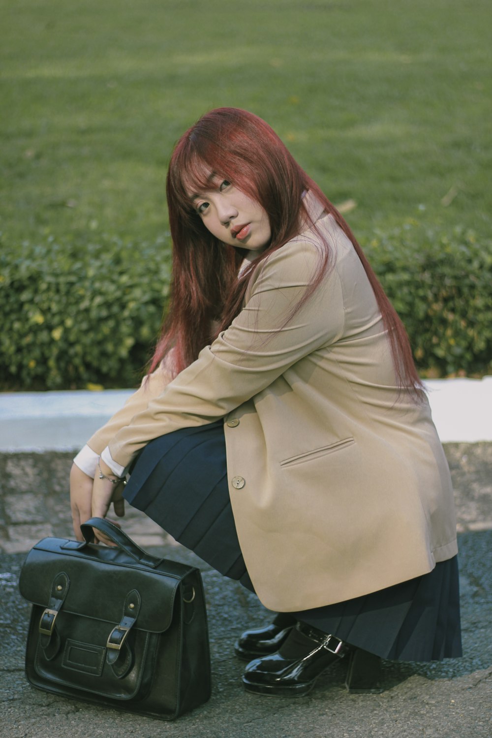 a woman sitting on the ground with a suitcase