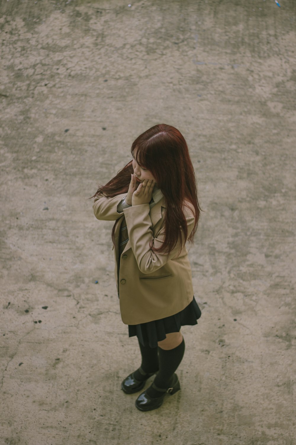 a woman standing in a parking lot talking on a cell phone