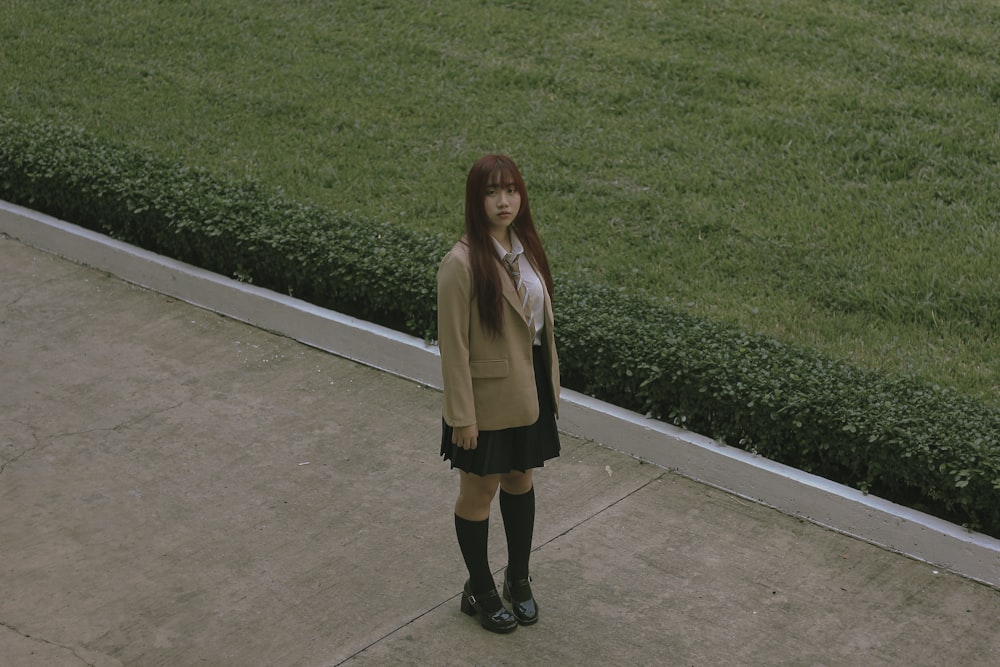 a woman standing in front of a lush green field