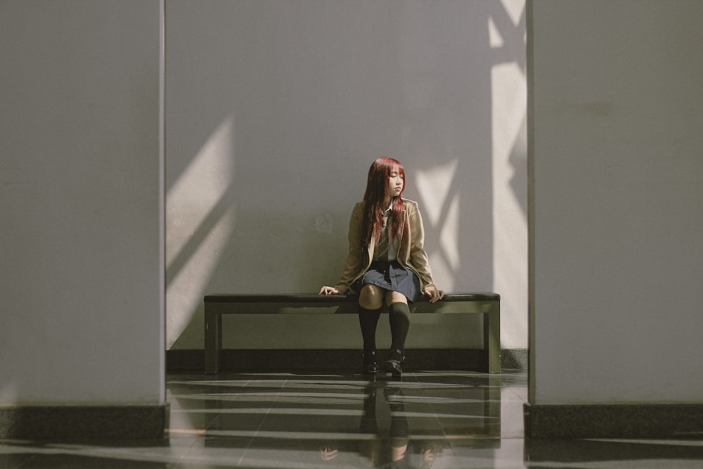 a woman with red hair sitting on a bench