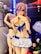 A colorful anime figure is posed with hands near the face, wearing a blue and white sailor-themed outfit. A price tag displays '£28.00'. There are other anime figures in the background, positioned on shelves with various lighting effects.