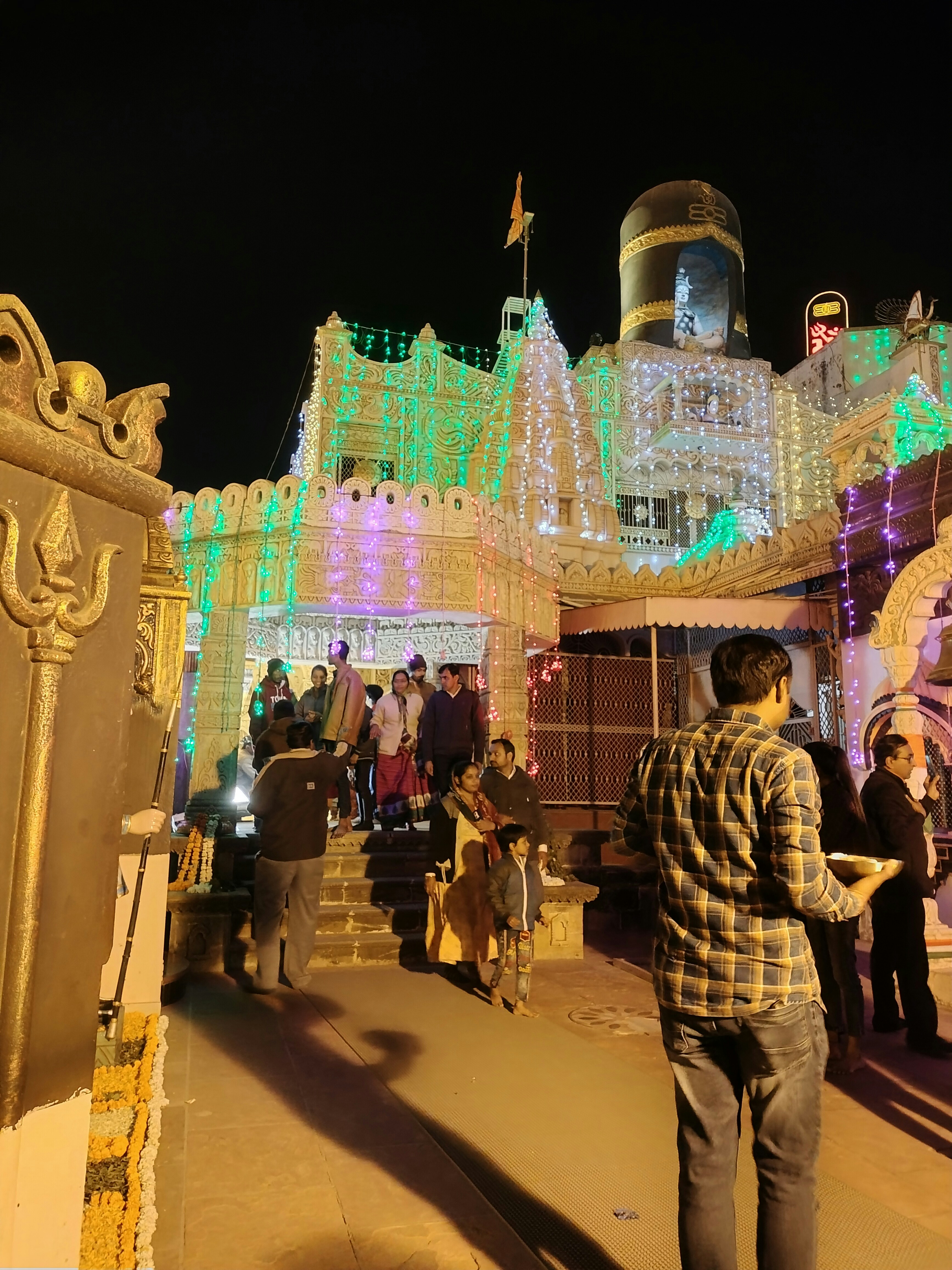 Ambaji temple illuminated at night with devotees