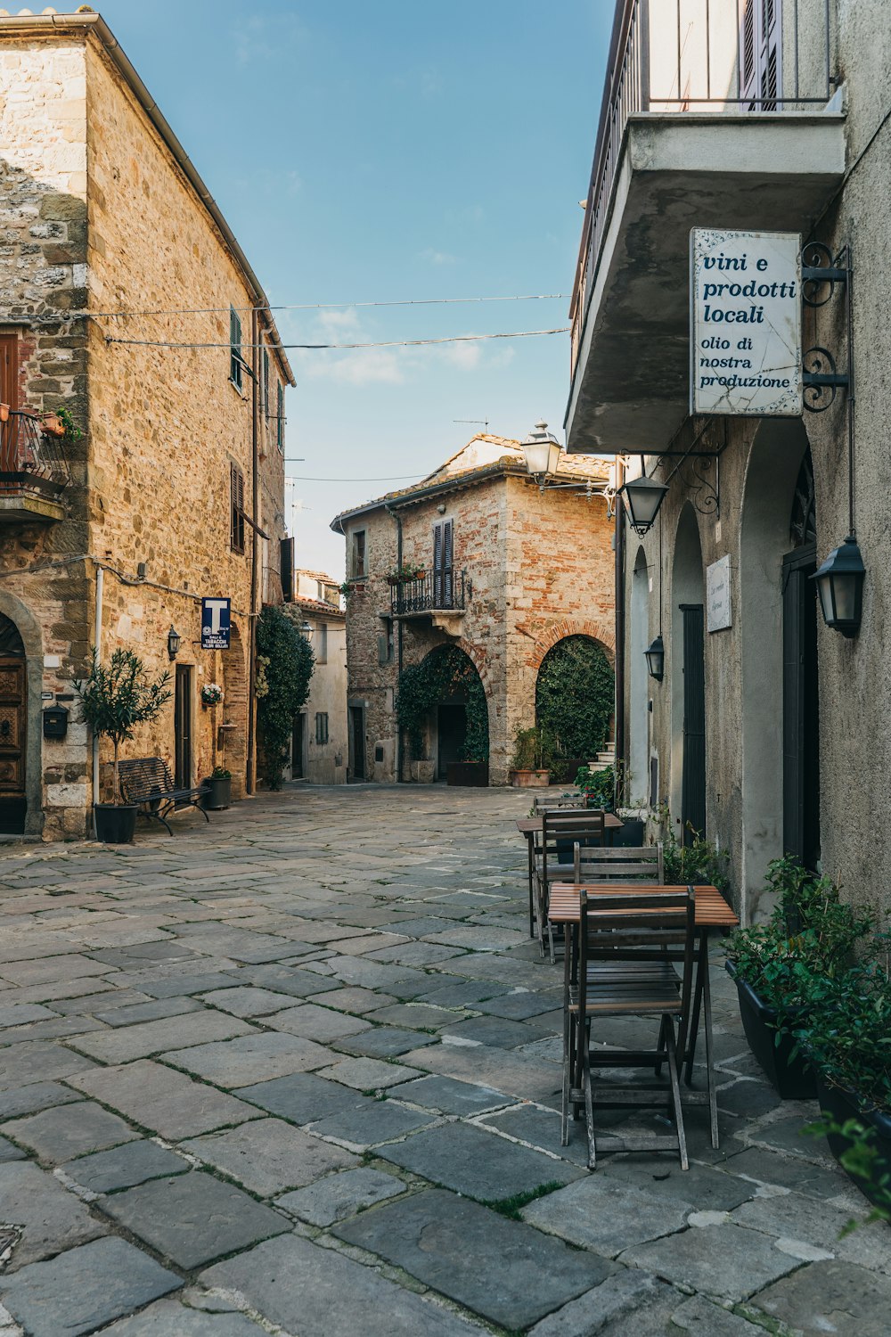 Una strada di ciottoli fiancheggiata da tavoli e sedie